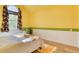 Cheerful bedroom with large window and yellow walls at 8016 E Fairmount Dr, Denver, CO 80230