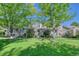 Two story townhome with green lawn, trees and walkway at 8016 E Fairmount Dr, Denver, CO 80230