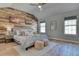 Large bedroom with vaulted ceilings, wood-look walls and plenty of natural light at 8016 E Fairmount Dr, Denver, CO 80230