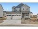 Two-story home with gray and blue siding, two-car garage, and landscaping at 39611 Congress Ln, Elizabeth, CO 80107