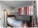 Small bedroom with a bunk bed and geometric curtains at 3040 W 66Th Ave, Denver, CO 80221