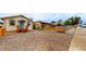 Tan bungalow with teal door, wood steps, and gravel driveway at 3040 W 66Th Ave, Denver, CO 80221