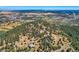 Aerial view showing home, surrounding trees and distant city at 801 Panorama Dr, Golden, CO 80401