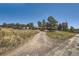 Home with driveway, trees and distant mountain view at 801 Panorama Dr, Golden, CO 80401