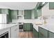 Stylish kitchen featuring green cabinets, marble countertops and a farmhouse sink at 13750 W 65Th Ave, Arvada, CO 80004