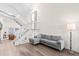 Spacious living room with L-shaped sofa, hardwood floors, and a grand staircase at 13750 W 65Th Ave, Arvada, CO 80004