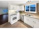White kitchen cabinets, stainless steel appliances, and a view into the living room at 4635 Sable St, Denver, CO 80239