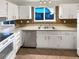 Kitchen with white cabinets, stainless steel appliances, and brick backsplash at 4635 Sable St, Denver, CO 80239