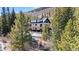 Rear view of a two-story home with wooden deck, nestled among pine trees in a snowy landscape at 6270 Highway 9, Breckenridge, CO 80424