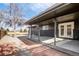 Covered back patio with brick accents and access to a fenced backyard at 3169 E Caley Ave, Centennial, CO 80121