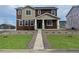 Two-story home with brown and beige siding, a walkway, and landscaped lawn at 2900 Nectar St, Strasburg, CO 80136