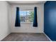 Bedroom with blue accent wall, carpet, and window with curtains at 12581 Elm St, Thornton, CO 80241