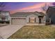 Tan house with a two-car garage and a well-maintained lawn at 20123 E Ithaca Pl, Aurora, CO 80013