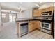 Open kitchen with light wood cabinets and stainless steel appliances at 7874 W 55Th Ave, Arvada, CO 80002