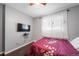 Bright bedroom with a double bed, TV, and hardwood floors at 9078 E Lehigh Ave, Denver, CO 80237