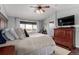 Large bedroom with hardwood floors, a ceiling fan, and a TV at 4899 Mt Cameron Dr, Brighton, CO 80601