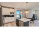 Modern kitchen with stainless steel appliances, island seating, and a sliding glass door at 27492 E 1St Ave, Aurora, CO 80018