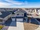 Two-story house with a gray roof and two-car garage, aerial view at 109 Racer St, Bennett, CO 80102