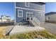 Backyard with concrete patio and stairs leading to the house at 109 Racer St, Bennett, CO 80102