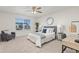 Bright bedroom with a queen bed, seating area, and workspace at 109 Racer St, Bennett, CO 80102