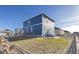 Side view of a two-story house with a gray and blue exterior and backyard at 109 Racer St, Bennett, CO 80102