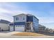 Two-story home with a gray and blue exterior, two-car garage, and landscaping at 109 Racer St, Bennett, CO 80102