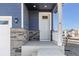 White front door with stone accents and a small covered porch at 109 Racer St, Bennett, CO 80102