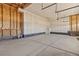 Unfinished garage with concrete floor and overhead door at 109 Racer St, Bennett, CO 80102