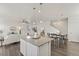Open concept kitchen and dining area with hardwood floors and modern light fixtures at 109 Racer St, Bennett, CO 80102