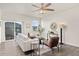 Living room with hardwood floors, sliding door to patio, and ceiling fan at 109 Racer St, Bennett, CO 80102