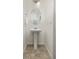 Small powder room with pedestal sink and oval mirror at 109 Racer St, Bennett, CO 80102