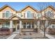 Tan two-story townhome with front porch and landscaping at 1456 Turnberry Dr, Castle Rock, CO 80104