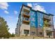 Modern apartment building with blue siding and brick accents at 487 Interlocken Blvd # 102, Broomfield, CO 80021