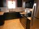 Modern kitchen with dark cabinetry, stainless steel appliances, and granite countertops at 12484 E Alaska Ave, Aurora, CO 80012