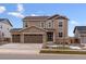 Two-story house with brown siding, three-car garage, and landscaping at 3813 N Elk St, Aurora, CO 80019