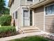 Tan two-story building exterior with private entrance and landscaping at 1250 S Monaco Pkwy # 2, Denver, CO 80224