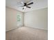 Primary bedroom with ceiling fan, carpet, and large window at 1250 S Monaco Pkwy # 2, Denver, CO 80224