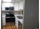 Updated kitchen with stainless steel appliances and light wood flooring at 1250 S Monaco Pkwy # 2, Denver, CO 80224