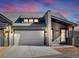 Modern exterior of a townhouse with a gray stone facade and a two-car garage at 3907 Piney Grove St, Evergreen, CO 80439