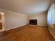 Hardwood floor living room with brick fireplace and view into kitchen at 950 S Potomac Ct, Aurora, CO 80012