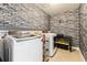 Convenient laundry room with washer, dryer and stylish brick wall at 8551 Orchard Way, Arvada, CO 80007