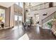 Two-story living room with hardwood floors, high ceilings, and a dining area at 8551 Orchard Way, Arvada, CO 80007