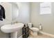 Clean powder room with pedestal sink, toilet, and tiled floor at 8551 Orchard Way, Arvada, CO 80007