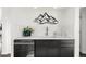 Modern wet bar with dark cabinetry, white countertops and a sleek design at 669 N Washington St # 901, Denver, CO 80203