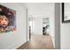 Light-filled hallway with hardwood floors and modern artwork leading to living area at 669 N Washington St # 901, Denver, CO 80203