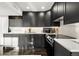 Modern kitchen with dark cabinetry, white countertops, and stainless steel appliances at 669 N Washington St # 901, Denver, CO 80203