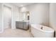 Soaking tub in primary bathroom with tile floor and vanity at 1737 Marlowe E Cir, Erie, CO 80516