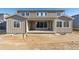 Back exterior of a two-story home with a covered patio and large windows at 1737 Marlowe E Cir, Erie, CO 80516