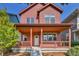 Two-story red home with a large covered porch at 9045 E 58Th Dr, Denver, CO 80238