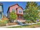 Two-story red home with a front porch and landscaping at 9045 E 58Th Dr, Denver, CO 80238